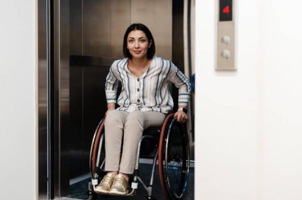 Woman in wheelchair exiting elevator